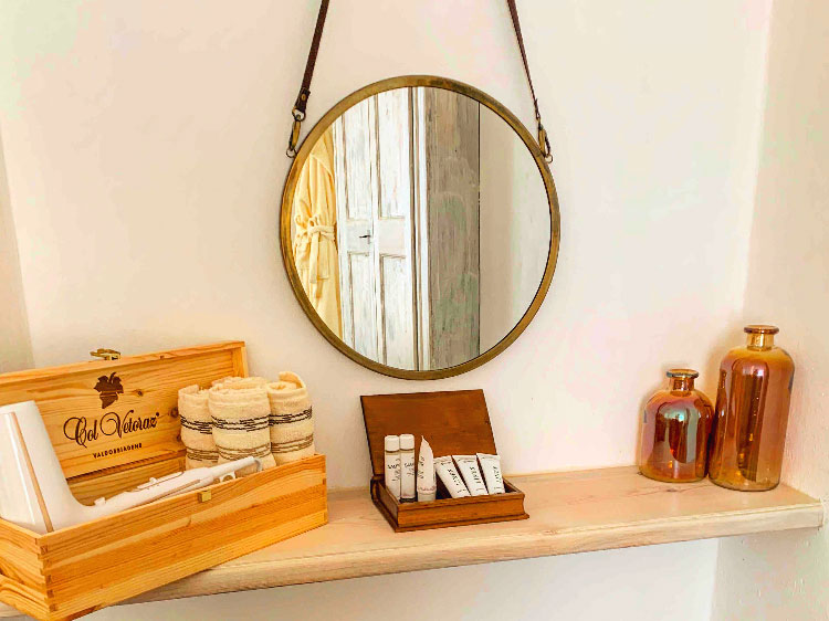 A mirror and the courtesy set in the bathroom of the Nano Wine Guesthouse. 